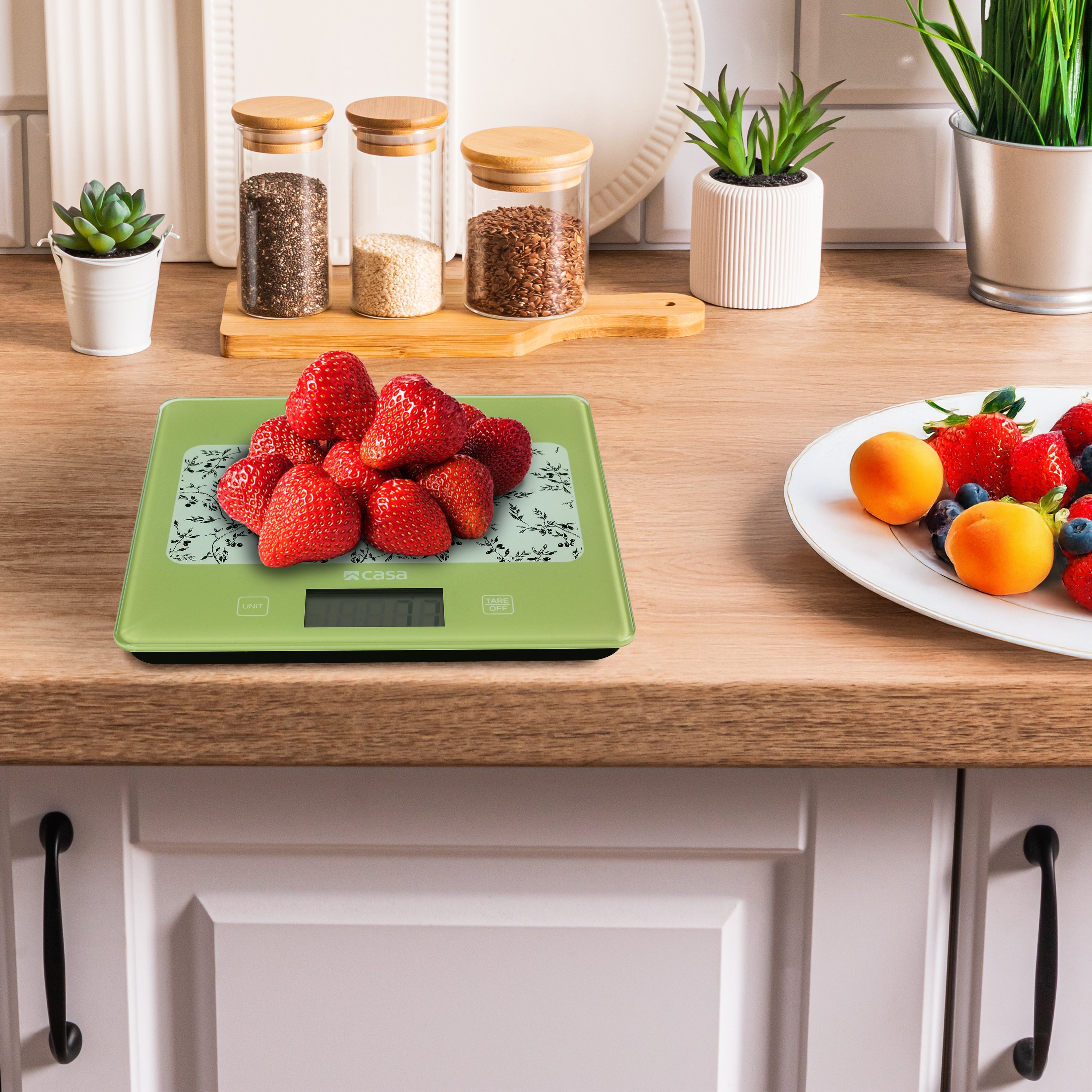 Green digital kitchen scale with floral design on a gray background