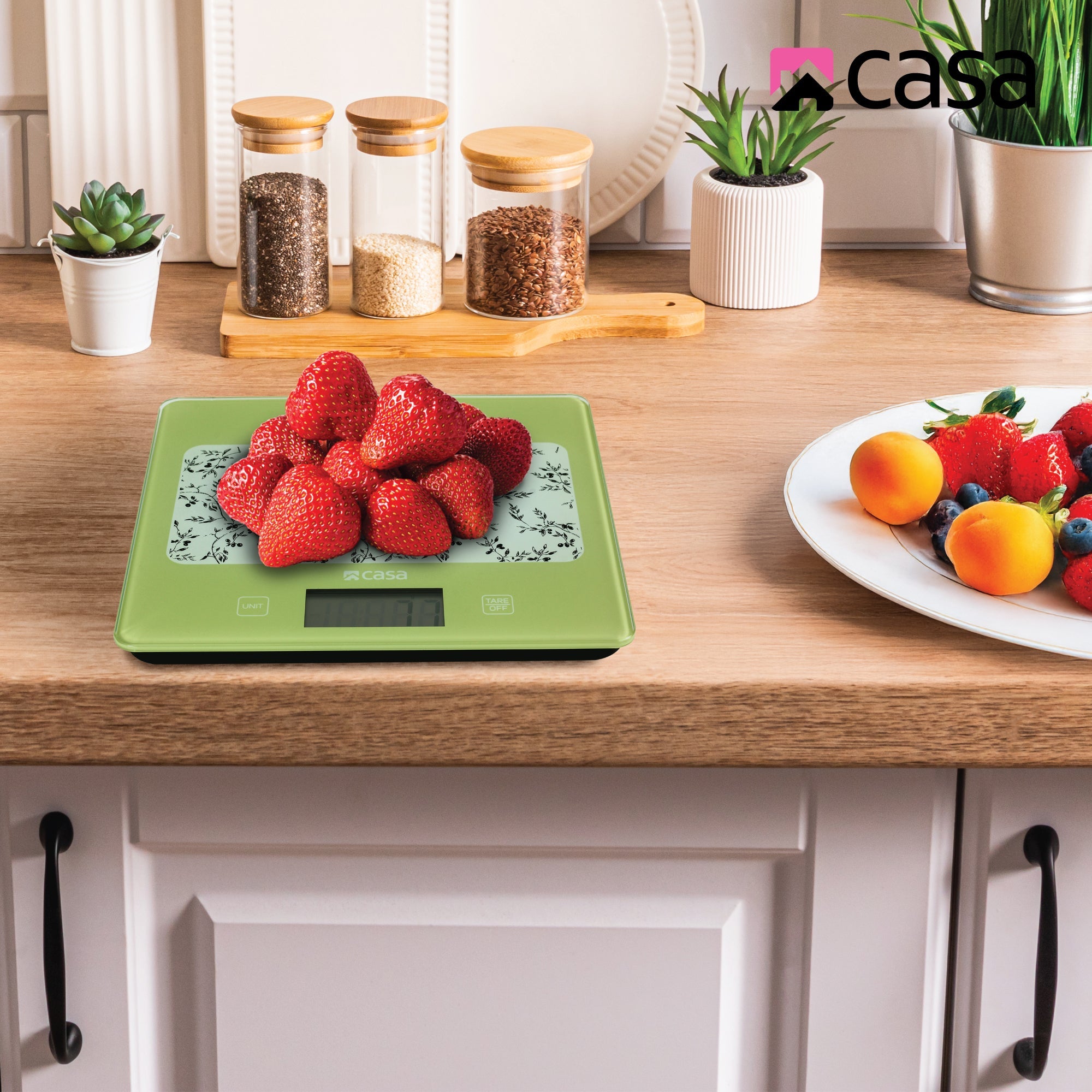 Green digital kitchen scale with floral design on a gray background